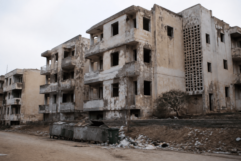Batiments negliges avec facades degradees et poubelles dispersees
