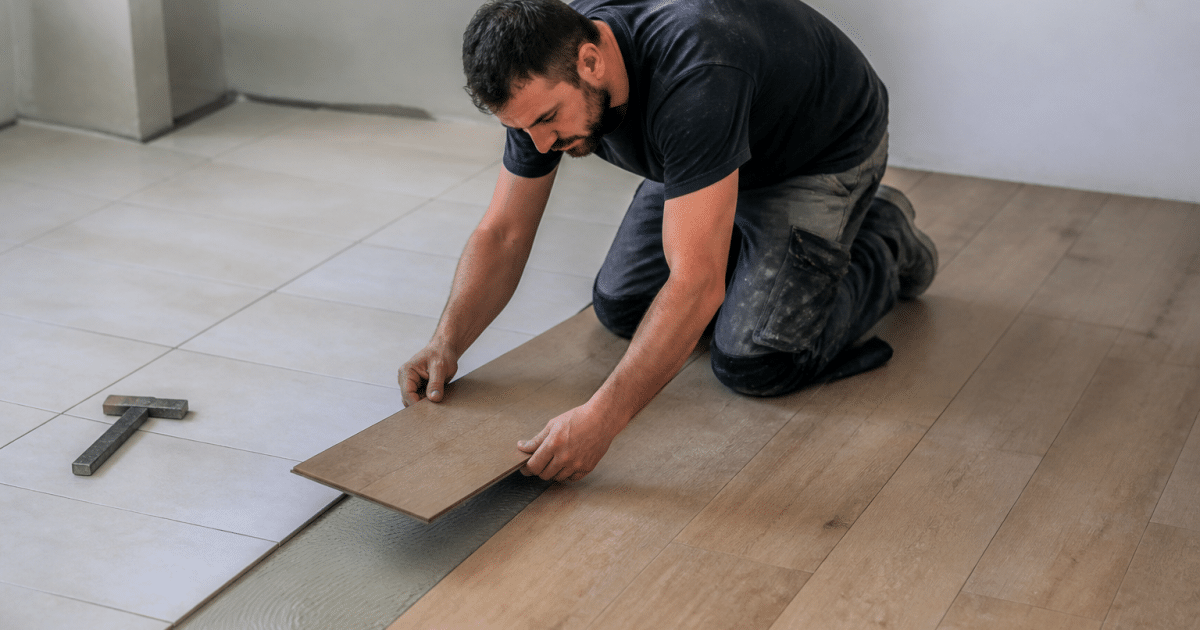 Ouvrier posant lames de bois sur carrelage blanc
