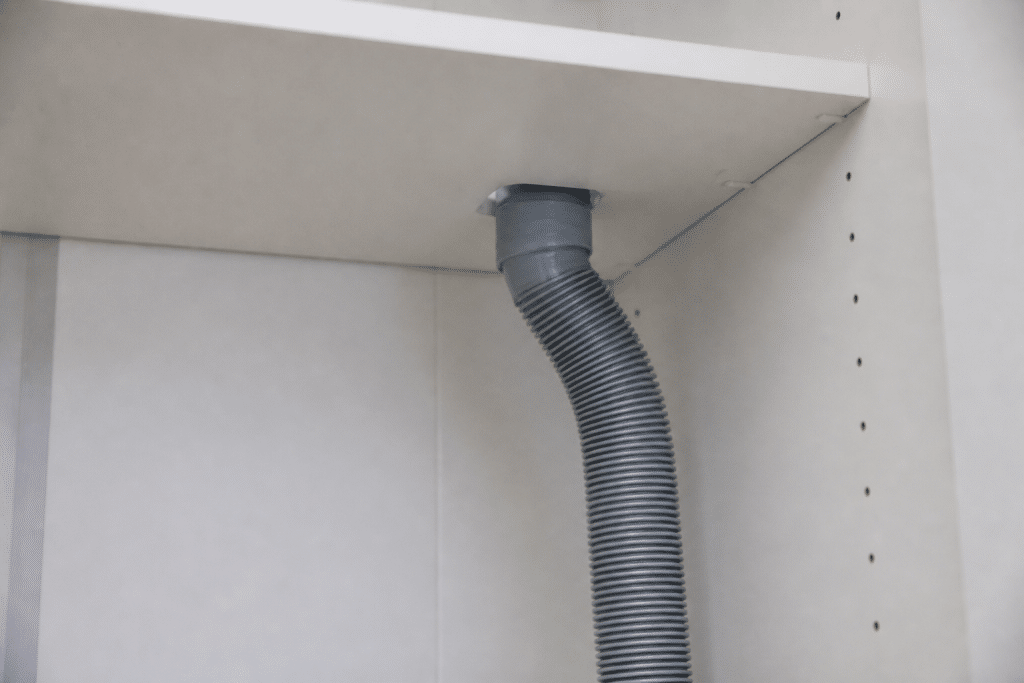 Tuyau ventilation gris installé interieur placard blanc