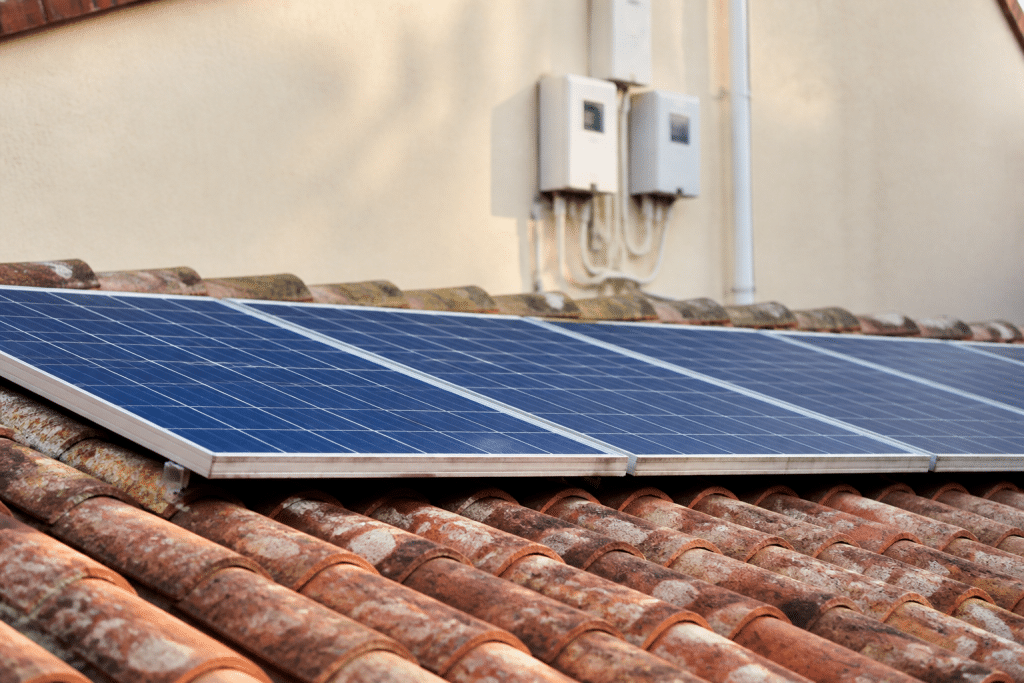 Panneaux solaires bleus sur toiture avec compteur électrique en arrière-plan
