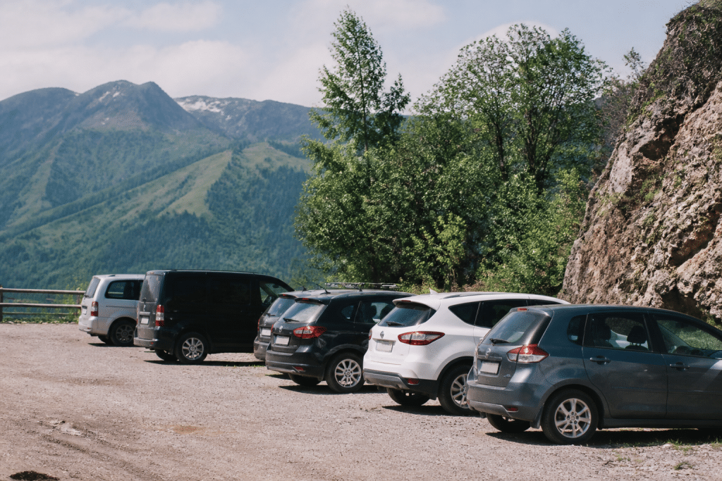Parking de montagne avec voitures garées près de panneaux routiers