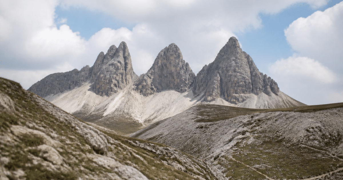 Trois pics rocheux s'elevant au-dessus d'un col montagneux